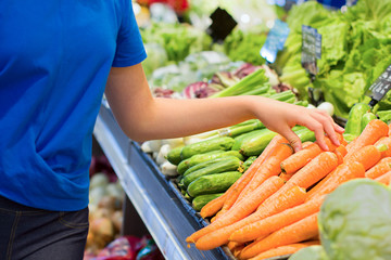 Female hand choosing vegetables in the store. Concept of healthy food, bio, vegetarian, diet.