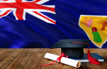 Turks And Caicos Islands education concept. Graduation cap and diploma on wooden table, national flag background. Succesful student.