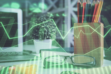 Financial chart hologram with glasses on the table background. Concept of business. Double exposure.