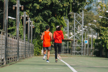Obraz premium young couple runner running on running road in city park;sport, people, exercising and lifestyle concept