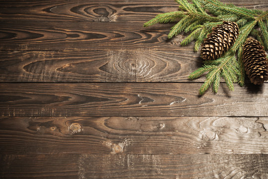 fir branches and cone on dark old wooden background