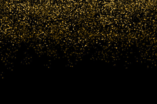 Golden confetti isolated on black background (clipping path) with bright festive tinsel of gold color for Christmas, new year, birthday party and greeting card decoration