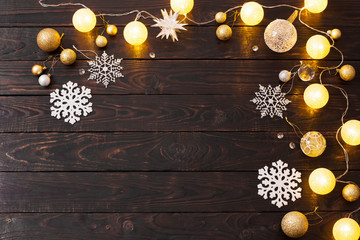 Christmas decorations with lights on dark wooden background