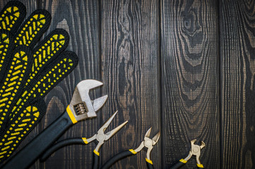 Tools for master builder on a wooden black vintage background