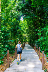 Obraz premium Young Woman Running on a Wooden Path in the Forest - Singapore 