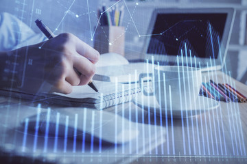 Financial chart drawn over hands taking notes background. Concept of research. Double exposure