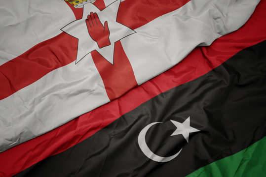 waving colorful flag of libya and national flag of northern ireland.