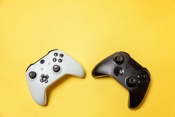 White and black two joystick gamepad, game console on yellow colourful trendy modern fashion pin-up...