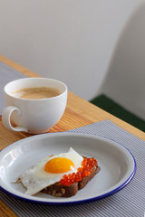 coffee and toast with fried egg and red caviar