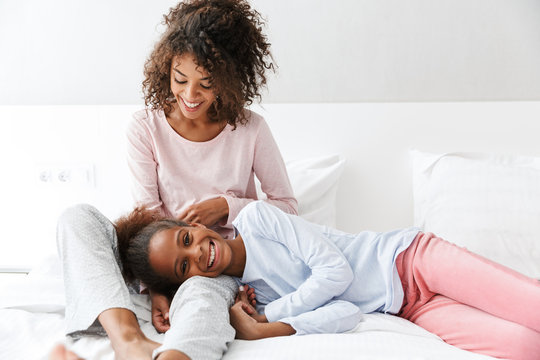 Image of cheerful african american woman and her little daughter at home - Powered by Adobe