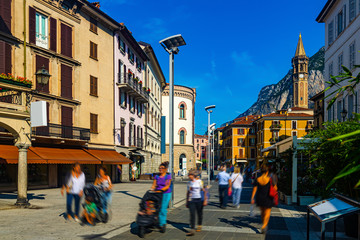 Fototapeta na wymiar Lecco street with bell-tower of Basilica