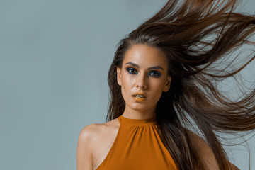 Young beautiful brunette with blue smokey eyes and yellow lips, professional makeup, contouring, a...