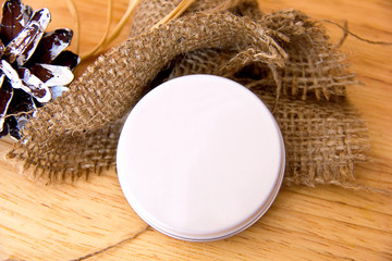 Pine cone burlap vanilla stick and white empty circle for inserting text on a wooden background, mock up for creating postcards