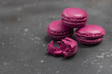 Obraz na płótnie Canvas Colorful french macarons cookies (macaroons) on a dark background. Dessert for served with tea or coffee break. Holiday gift for women.