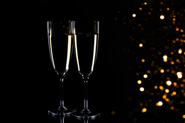 Glasses with champagne on black background, New Year background