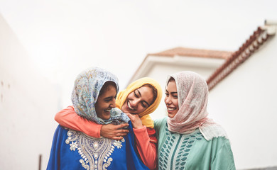 Happy Muslim girlfriends having fun walking outdoor - Arabian girls sharing time and conversation...
