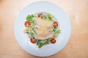 Plate with chicken salad on table. Healthy Grilled Chicken Caesar Salad with Cheese and Croutons.