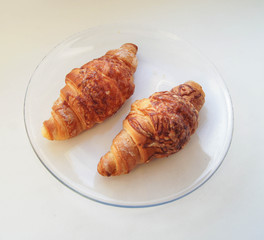 two croissants on a clear plate