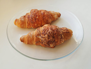 two croissants on a clear plate