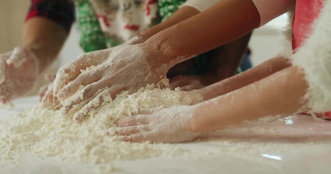 Tilt down video shows of family baking cookies for Christmas  