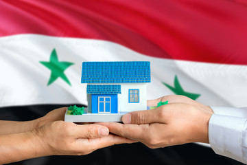 Syria real estate concept. Man and woman holding miniature house in hands. Citizenship theme and...