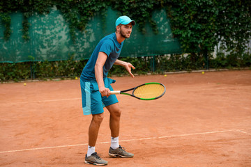 Fototapeta na wymiar Man playing tennis at outdoor court.