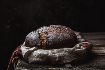 Bread on a rural on a black background. homemade baking
