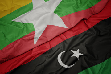 waving colorful flag of libya and national flag of myanmar.