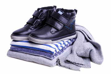 stack of children's sweatshirts, boots and a scarf