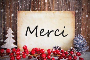 Fototapeta na wymiar Paper With French Text Merci Means Thank You. Christmas Decoration And Wooden Background With Snow