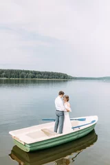 Foto op Canvas  Stylish wedding in European style. Happy couple on a boat on the lake. © pavelvozmischev