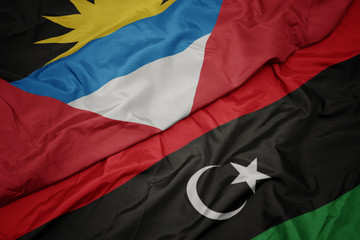 waving colorful flag of libya and national flag of antigua and barbuda.