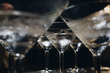 cocktail glasses with ice. the bartender cools the glasses before making cocktails.