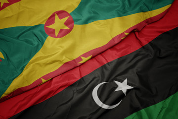 waving colorful flag of libya and national flag of grenada.