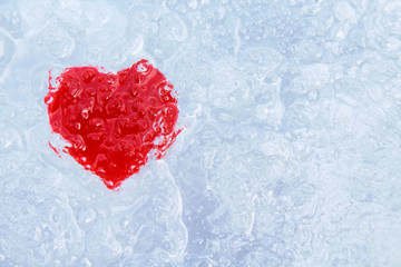 Frozen red heart in ice. Close-up. Background. Texture.