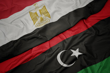 waving colorful flag of libya and national flag of egypt .