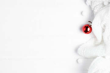 White winter Christmas background with a warm scarf and red decoration with a copy space.