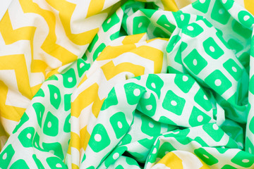 Crumpled texture fabric background with bright yellow and green color with a pattern.