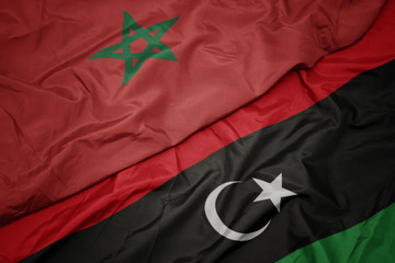 waving colorful flag of libya and national flag of morocco.