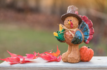 Thanksgiving concept with turkey pumpkins and leaves in warm sun.  Fall scene background.