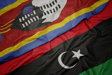 waving colorful flag of libya and national flag of swaziland.