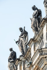 Fototapeta na wymiar Very old roof statutes of high ranked priests lined up in historical downtown of Dresden, Germany, details, closeup