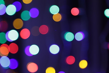 Multi-colored bokeh lights on a dark background. Close-up
