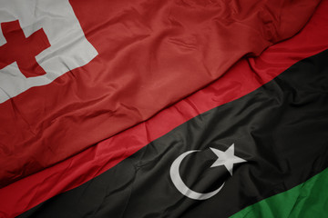 waving colorful flag of libya and national flag of Tonga .