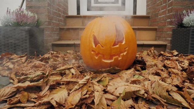 40% of realtime slow motion shot of halloween pumpkins with smoke in front of a house