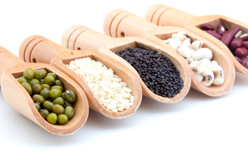 Flat lay composition of organic whole grains seeds or natural cereal in wooden scoop isolated on white background