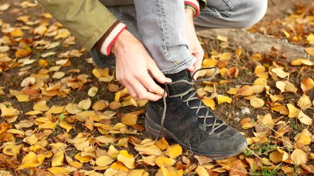 A man laces his shoes. Tie shoelaces on shoes