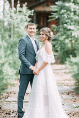 Stylish couple on the background of a wooden temple. Wedding in nature in the woods.