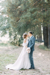 Fototapeta na wymiar Stylish European wedding at sunset. Happy couple in the forest in nature.