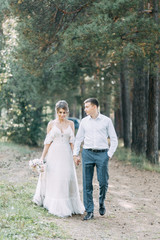Fototapeta premium Stylish European wedding at sunset. Happy couple in the forest in nature.